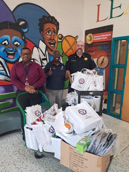 Volunteers organizing school supplies in boxes